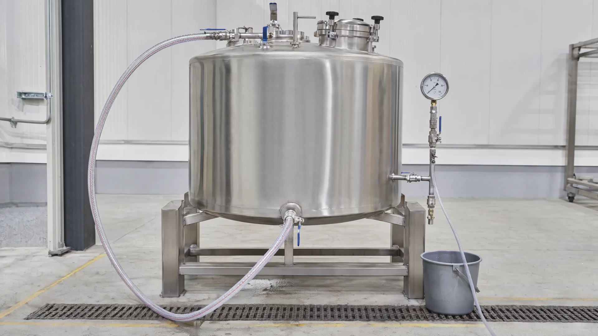 Controlled tank-body hydrostatic water-test setup with generic gauge and connected hose